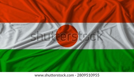 Niger flag with fabric texture background. National flag of Niger with cloth texture