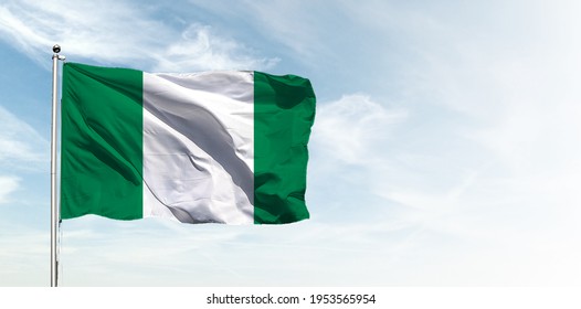 Nigeria flag in the blue sky. Horizontal panoramic banner.