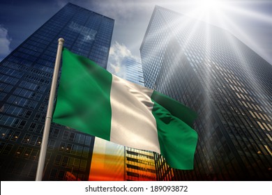 Nigeria National Flag Against Low Angle View Of Skyscrapers At Sunset