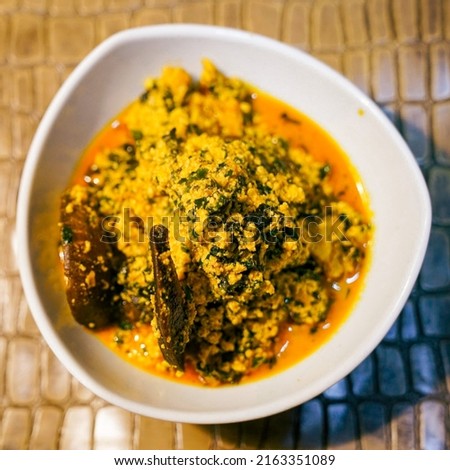 Nigerian food: Egusi Soup and snail in White breakable plate