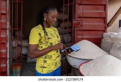 Nigerian Market Woman Using Point of Sale Machine to Confirm Payment for her Goods and Services