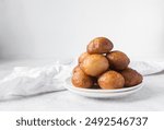 nigerian puff-puff on a white plate, nigerian fried dough balls, homemade bofrot on white dish