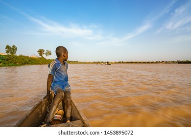 Nigerien fisherman kid watching Niger river while fishing at sunset in Niamey in Niger in Africa 25 june 2019