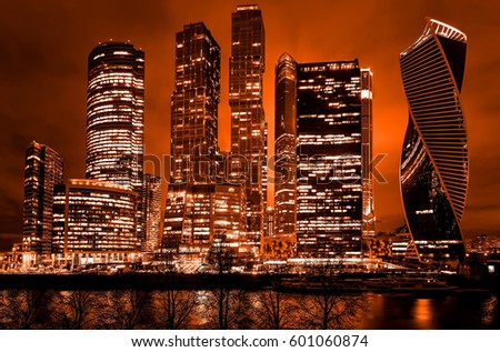 Night architecture - skyscrapers with glass facade. Modern buildings in red tone.