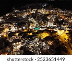 Göreme at night becomes a mystical scene, with moonlight casting shadows over ancient cave dwellings in Cappadocia, creating a surreal atmosphere.