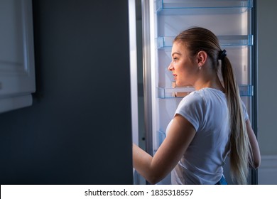 Night Bite. Cheerful Mature Woman Opening Refrigerator And Posing In Profile