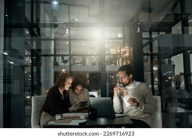 Night business, people and eating fast food in office with technology, planning and collaboration. Young employees, eating and working late online in dark agency, creative company and diversity group - Powered by Shutterstock