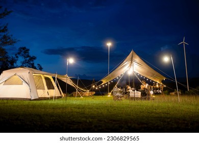 Night camping scenes, long exposures in moving parts are blurry.
Night camping with tent accommodation and relaxation seats, with two young Asian teenagers having dinner inside the tent. - Powered by Shutterstock