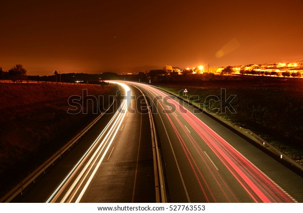 Night car trails on a calm\
road