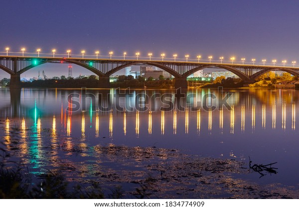 Night city bridge\
lighting. Beautiful reflection of night lights on water surface.\
Long exposure\
photography.