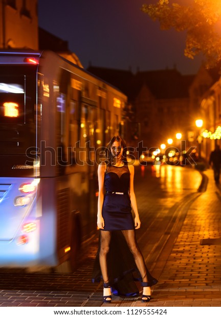 Night city with princess in celebrity style.\
Fashion and beauty of business lady. Sexy girl in elegant dress.\
Luxury woman in evening dress at night city go to prom on bus. Girl\
with glamour makeup