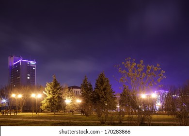 The Night City With Trees Parks And By Passing Cars