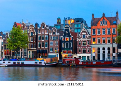 Night city view of Amsterdam canal, typical dutch houses and boats, Holland, Netherlands. 