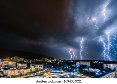 night city view under thunderstorm with strike of lightning. Powerful thunderbolt during thunderstorm in the city. Cloud to ground electric lightning behind the city.  - Powered by Shutterstock