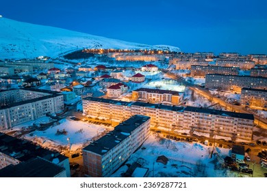Night citycape of Kirovsk. Houses in evening illumination. Polar city in winter. (Kirovsk, Russia, Murmansk Oblast, Kola Peninsula, known as Khibinogorsk, cold winter weather)