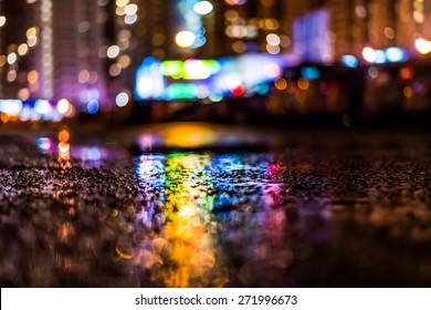 Night cityscape, colored lights reflected in the wet asphalt after rain. View from the level of asphalt - Powered by Shutterstock