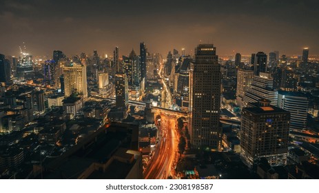 Night cityscape skyline panorama of modern Bangkok city and transport light trails on highway. Illuminated skyscrapers and moving vehicles lights on the road. cinematic color. High-angle view - Powered by Shutterstock