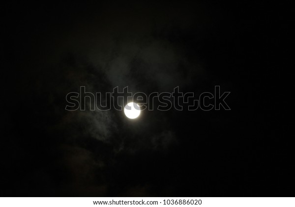 at night in\
the cloudy sky a full moon\
shines