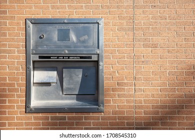 A Night And Day Deposit Box Drop Off On The Light Brown Brick Wall