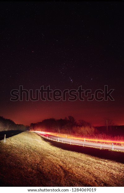 Night driving\
traffic on the coastline with light trails and stars in the dark\
winter night sky. German Baltic Sea Darßer Ort, Weststrand\
coastline at Fischland-Darss-Zingst\
