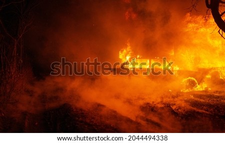 Night fire emergency with burning automobile ablaze