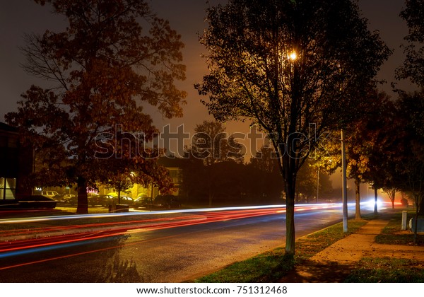 night fog light from cars\
residential area Rear lights of car on road in dark foggy winter\
evening