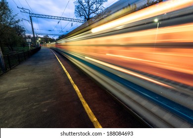 Night high-speed train in motion blur showing light trails in the station