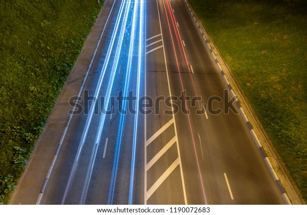 Night highway with car\
light streaks. Night light painting stripes. Long exposure\
photography. Copy space