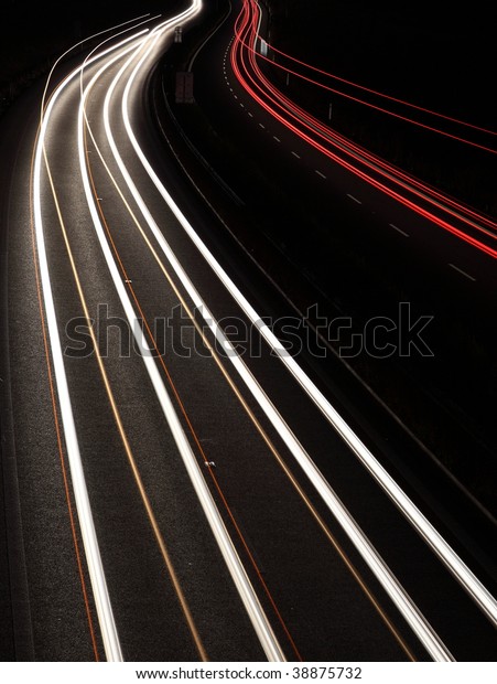 Night highway (Cars in a rush moving fast on a
highway (speedway) at the
nightfall
