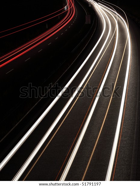 Night highway (Cars in a rush moving fast on a\
highway (speedway) at the\
nightfall