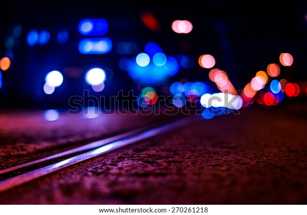 Night highway with rails,\
car go over it. View from the level of asphalt, image in the\
purple-blue toning