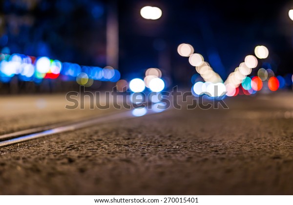 Night highway with rails, cars go\
over it. View from the level of asphalt, in blue\
tones