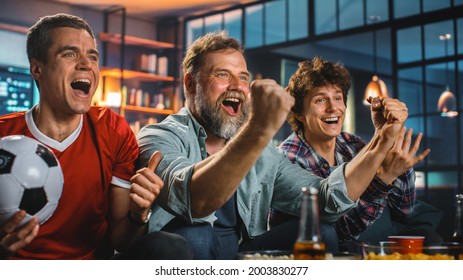 Night At Home: Three Joyful Soccer Fans On A Couch Watch Game On TV, Celebrate Victory When Sports Team Wins Championship. Friends Cheer For Favourite Football Club Play.