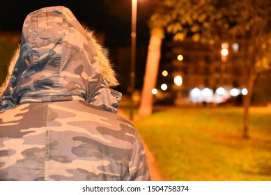 Night hooded man in the street illuminated by lamps - Powered by Shutterstock