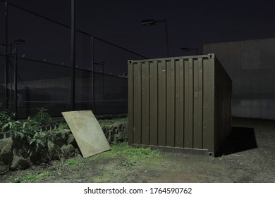 Night Image Of An Old Shipping Container At A Small Worksite Being Used To Work From And For Storage Of Materials And Tools For Security.