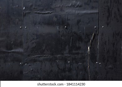 Night Image Of Textures On A Wall Of Black Painted Weathered Plywood On A Building Worksite Fence.