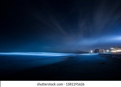 A Night At The Imperial Beach, San Diego. Long Exposure View Of The Ocean Waves And Lights Of The Houses. 