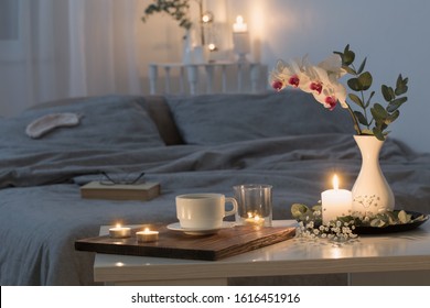 night interior of bedroom with flowers and burning candles