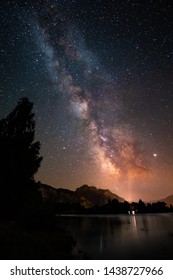 Night landscape with colorful Milky Way in Bavaria Forggensee. Starry sky with hills at summer. Beautiful Universe. Space background