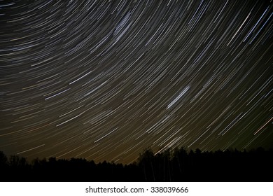 Night landscape with traces of the stars in the night sky on background of a dark forest - Powered by Shutterstock