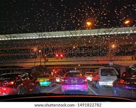 raindrop​ on​ windshield​ and​ trafficjam​, night light