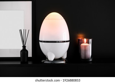 Night Light, Ultrasonic Humidifier And Candle On A Black Background. Cozy Home Corner. Picture Frame And Photo Mockup