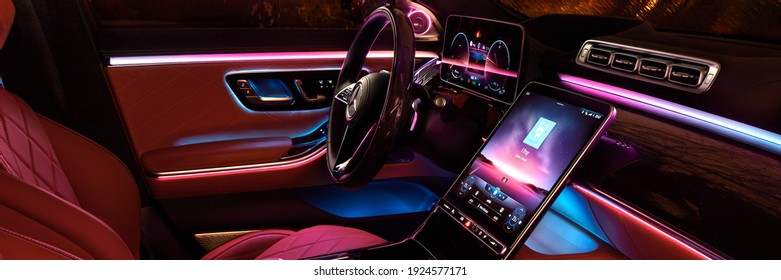 Night lighting cabin of luxury Mercedes S Class finished with real wood and leather and a huge multimedia screen MBUX. Rainy night. Katowice,Poland - 02.02.2021