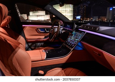 Night lighting cabin of luxury Mercedes S Class finished with real wood and leather and a huge multimedia screen MBUX. View of the Silesian Museum. Katowice,Poland - 02.02.2021