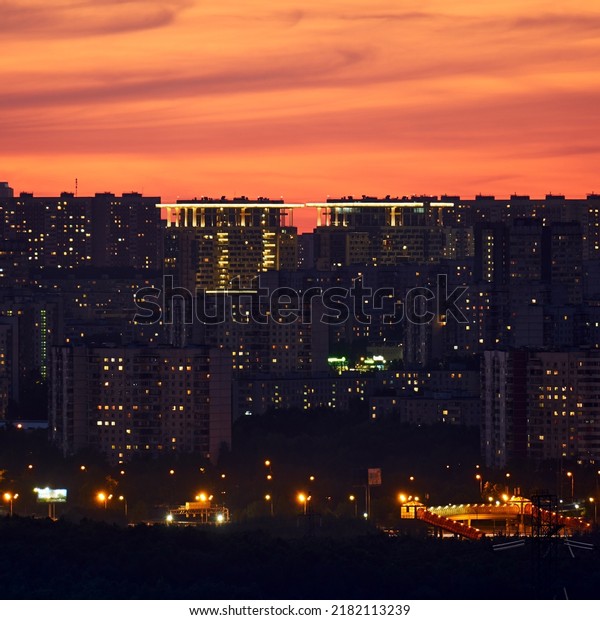 Night lights and\
illuminated windows of houses of the evening falling asleep city,\
night urban landscape