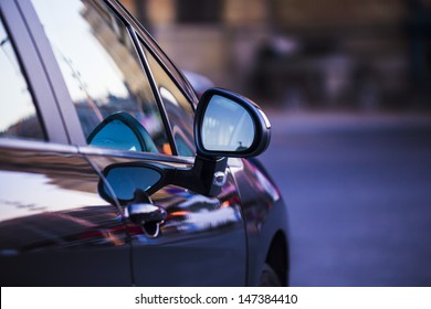 Night Lights Reflected In A Parked Car