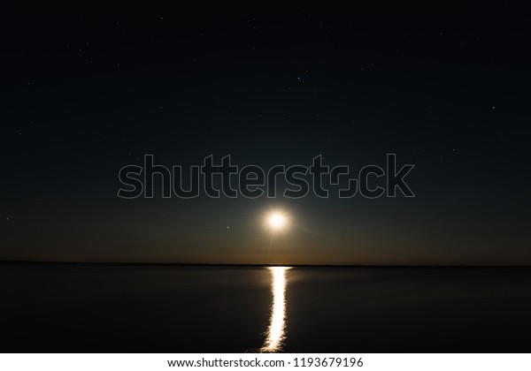 Night\
moon sky, full moon, Moon over the lake. Night landscape.\
Reflection of the rays from the moon in the\
water.
