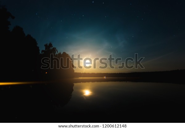 Night\
moon sky, full moon, Moon over the lake. Night landscape.\
Reflection of the rays from the moon in the\
water.