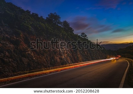 night mountain road with car light trails