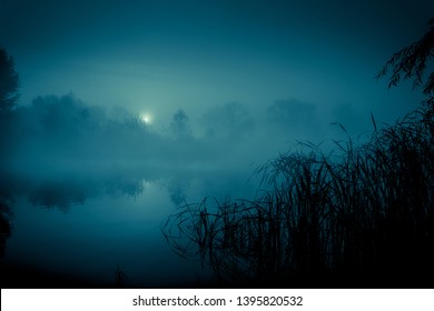 Night mystical scenery. Full moon over foggy river.